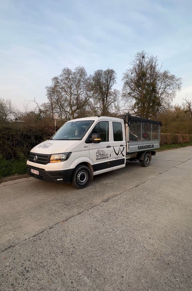 Afbeelding van Willem voor zijn bus, met een glimlach op zijn gezicht.